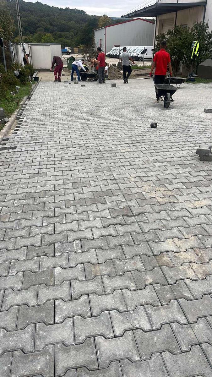 Long double-T paved yard with crew at work